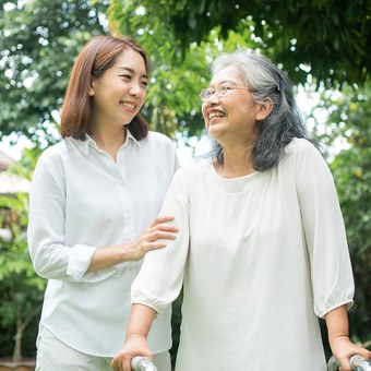 요양보호사와 어르신, 정원에서 함께 걷는 모습